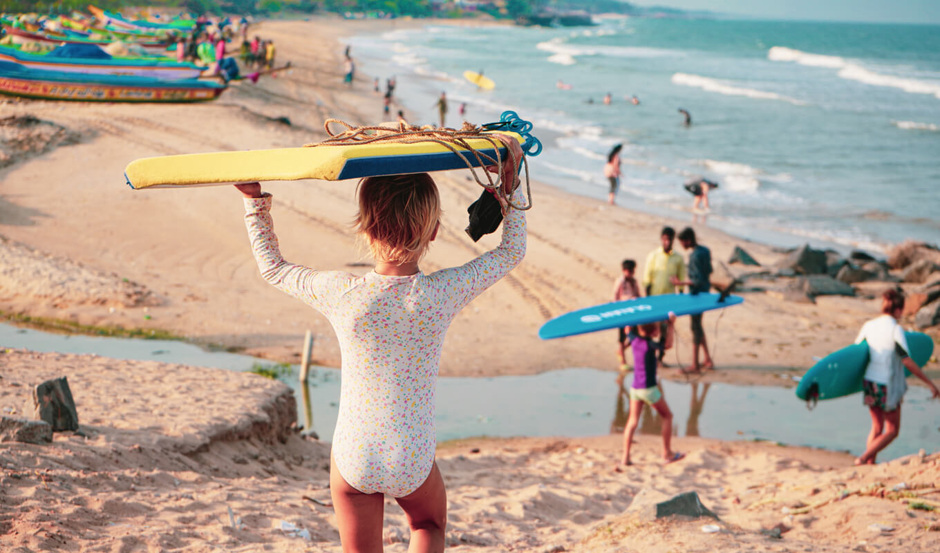 Kids wearing a rash guard while heading to the beach