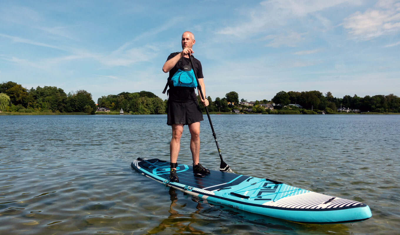 Man wearing a life jacket paddling using GILI meno touring paddle board