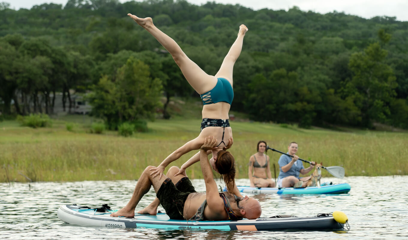 Man and a woman performing a advanced yoga pose on GILI komodo inflatable paddle boards