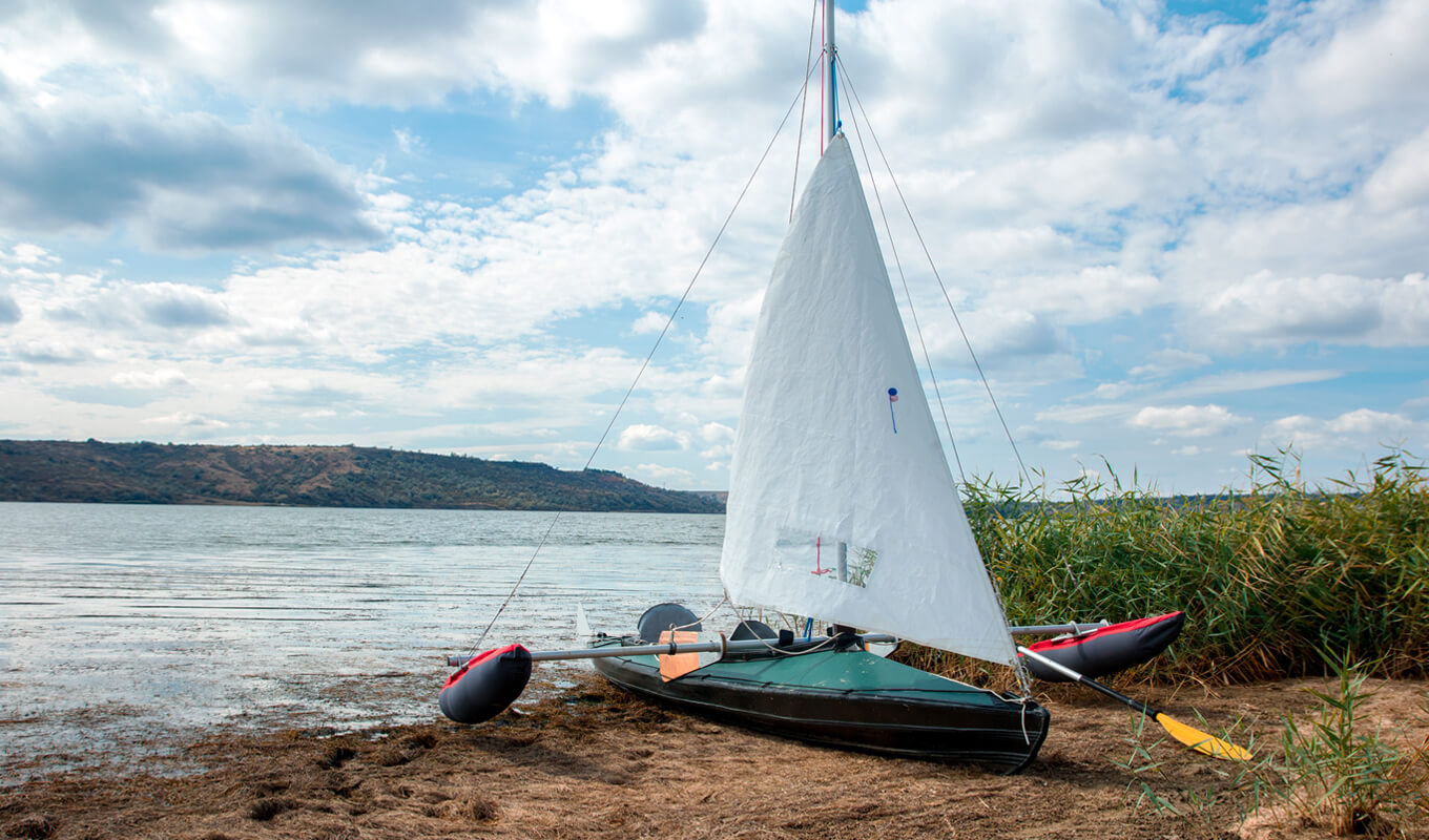 Green kayak with white sails