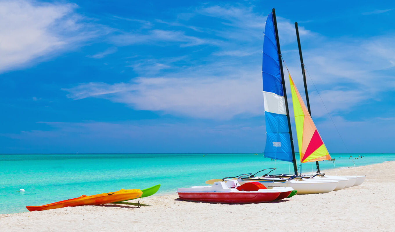 Kayak with a sail docked at the beach