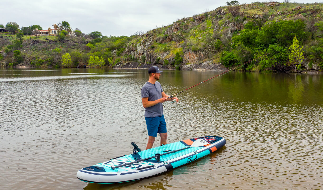 Man fly fishing on a GILI komodo inflatable paddle board