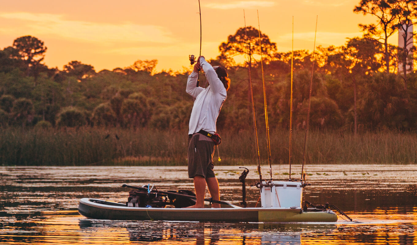 Man fishing on a paddle board with all fishing accessories