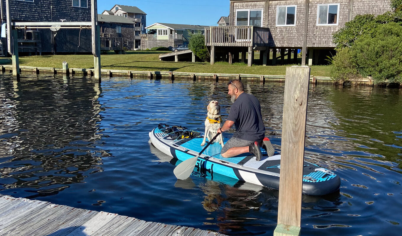 Man and his dog on a gili manta inflatable paddle board