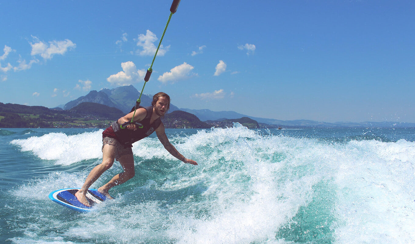 Man wearing a life jacket surfing on wave